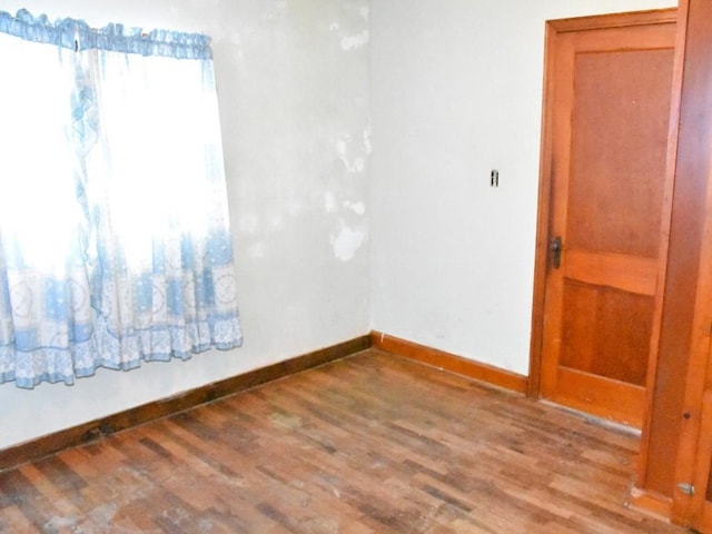 unfurnished room featuring wood finished floors and baseboards