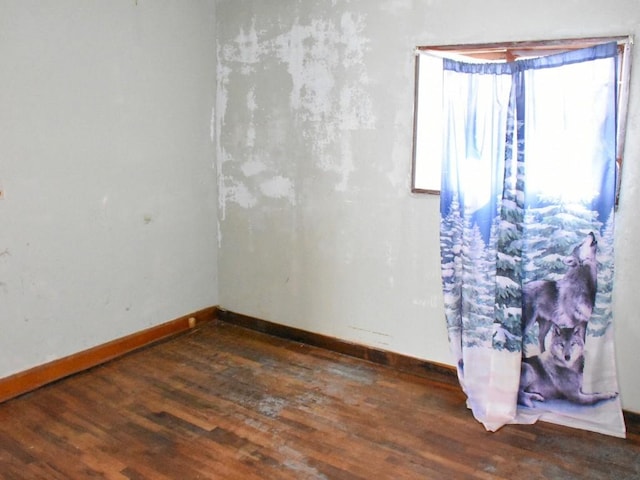 spare room with dark wood finished floors and baseboards