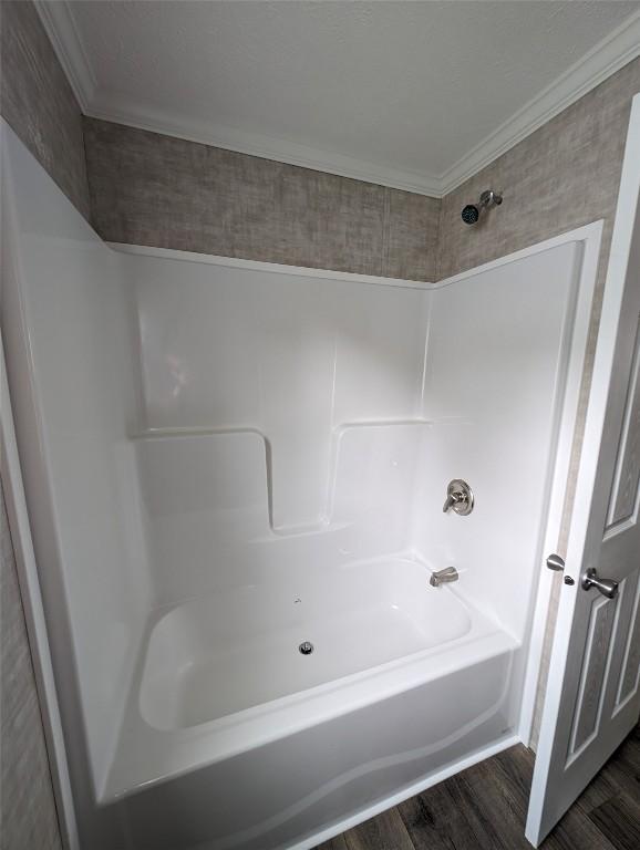 bathroom featuring wood-type flooring,  shower combination, and ornamental molding