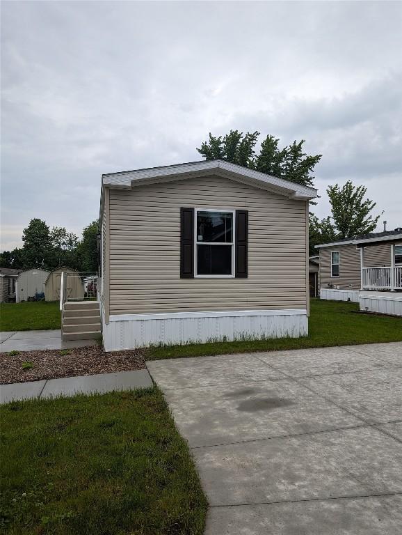 view of property exterior with a yard and a shed