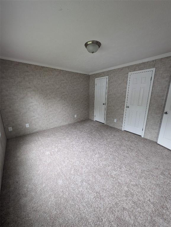 unfurnished bedroom featuring carpet floors and crown molding