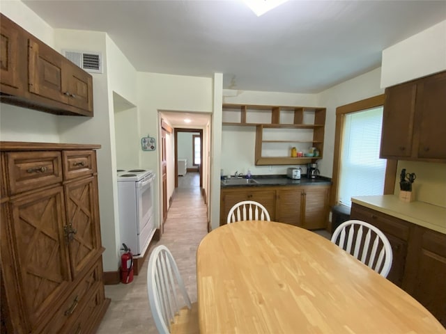 kitchen featuring sink, white electric range oven, and plenty of natural light