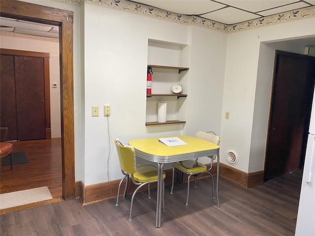 dining area featuring built in shelves and dark wood-type flooring