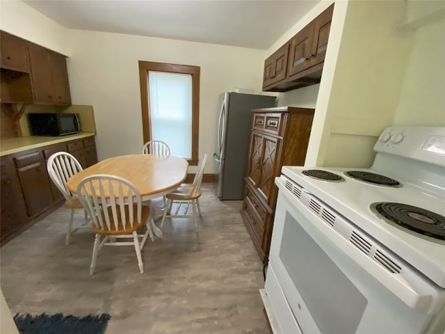 kitchen with electric range and stainless steel refrigerator