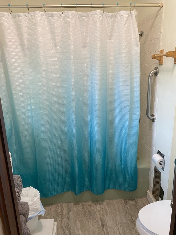 bathroom featuring shower / bath combination with curtain and toilet