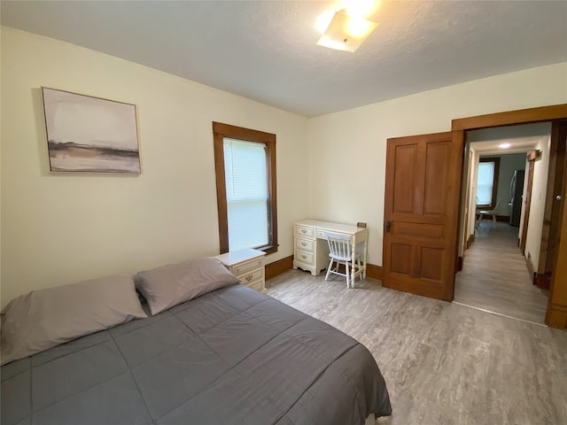 bedroom with light hardwood / wood-style flooring and a textured ceiling