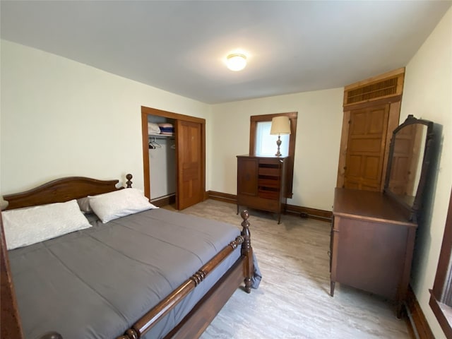 bedroom with light hardwood / wood-style floors and a closet