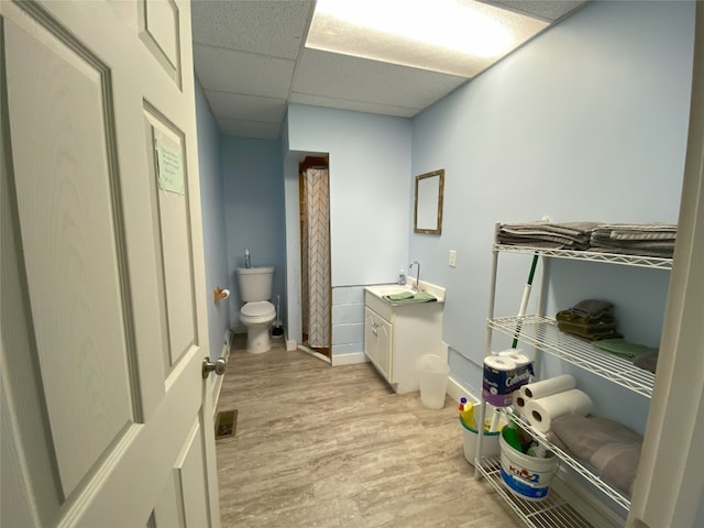 bathroom featuring a paneled ceiling, toilet, vanity, and hardwood / wood-style flooring