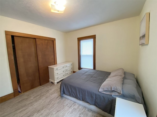 bedroom featuring light wood-type flooring and a closet