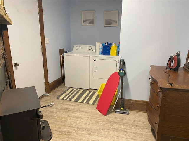 laundry area with light hardwood / wood-style flooring and washing machine and clothes dryer