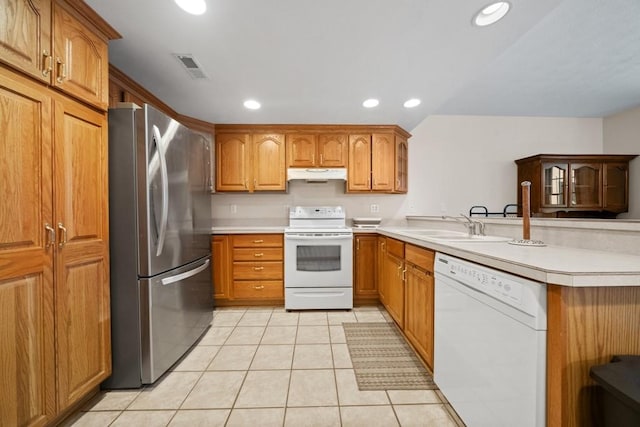 kitchen with light tile patterned floors, kitchen peninsula, sink, and white appliances