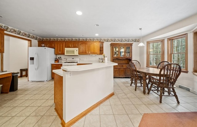 kitchen with decorative light fixtures, light tile patterned floors, and white appliances