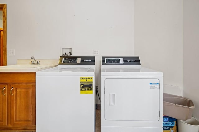 laundry room featuring cabinets, separate washer and dryer, and sink