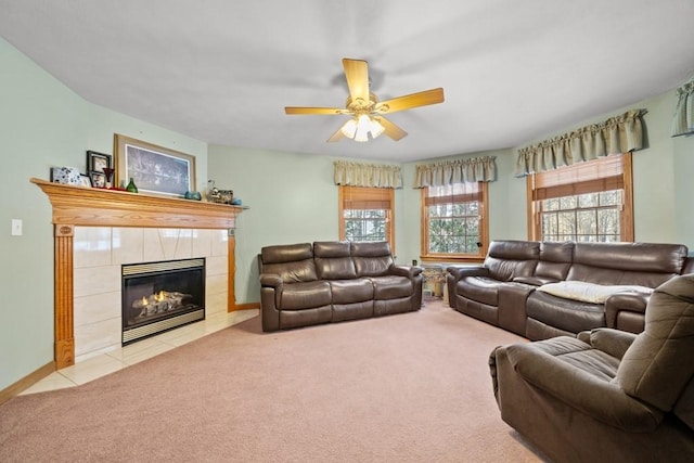 carpeted living room with ceiling fan and a tile fireplace