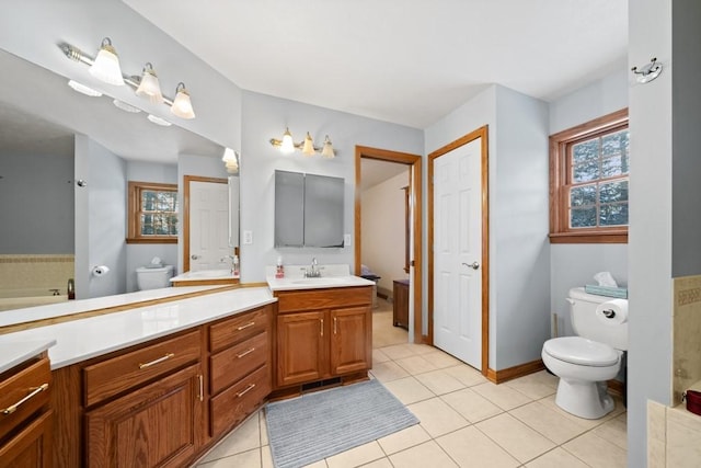 bathroom with a bathtub, toilet, vanity, and tile patterned flooring