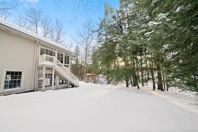 snowy yard with a sunroom