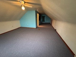 bonus room featuring ceiling fan, lofted ceiling, and dark colored carpet