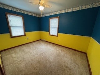 empty room featuring ceiling fan, a healthy amount of sunlight, and carpet floors