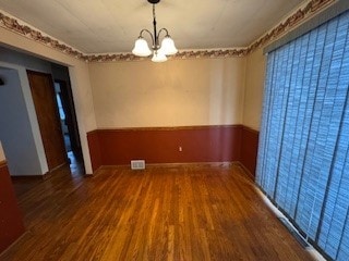 unfurnished room with dark hardwood / wood-style flooring and a chandelier