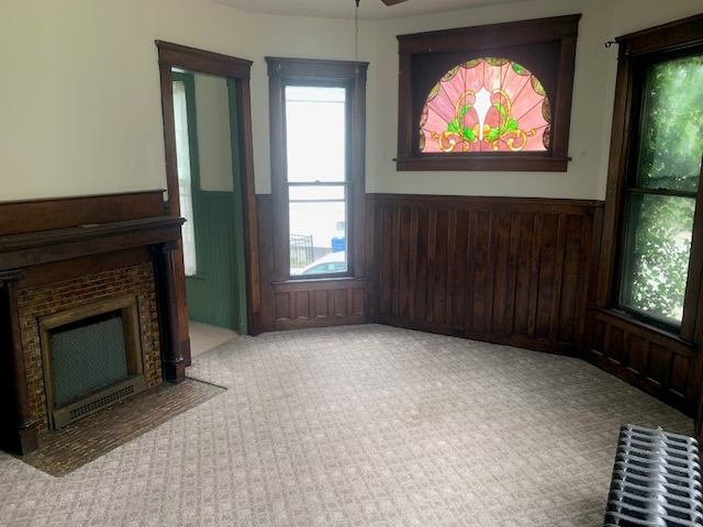 760-762 Park Ave, Meadville, PA 16335 - unfurnished living room with carpet floors, a wainscoted wall, radiator heating unit, a ceiling fan, and a fireplace with flush hearth