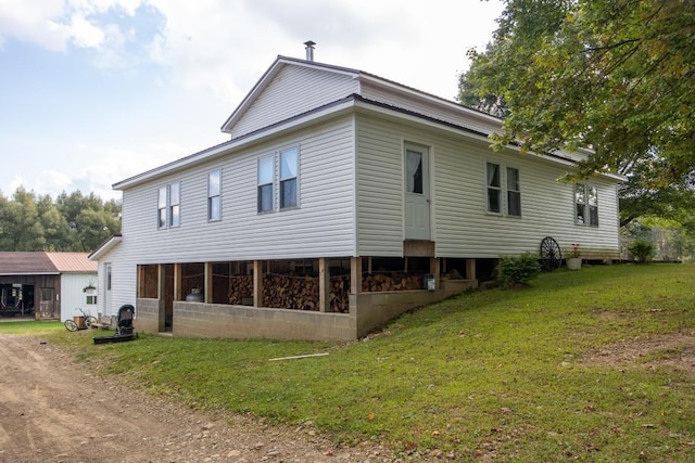 rear view of property featuring a yard