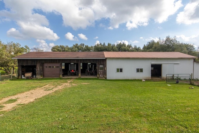 back of house with a lawn and an outbuilding