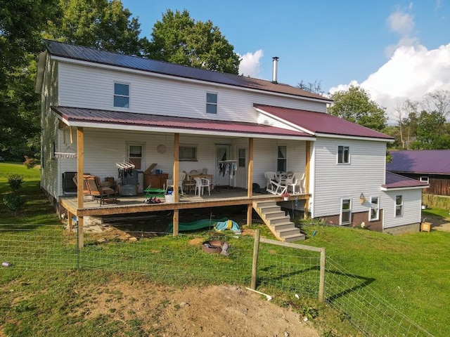 rear view of house with a wooden deck and a yard