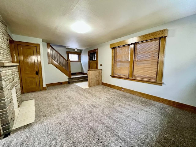 unfurnished living room featuring light carpet and a textured ceiling