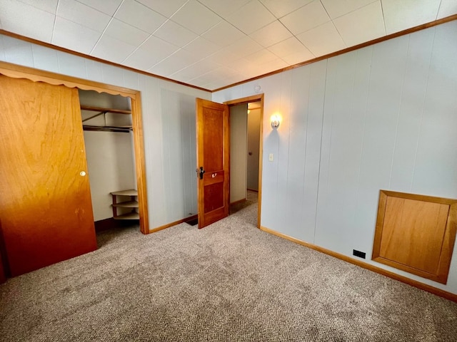 unfurnished bedroom featuring light colored carpet, a closet, and crown molding