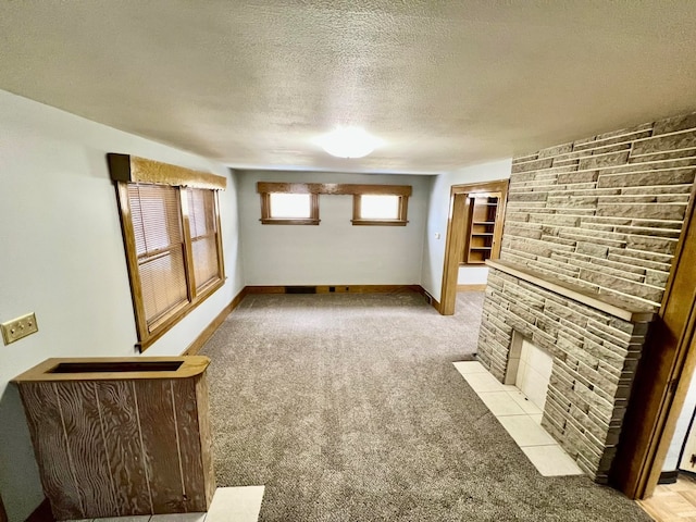 unfurnished living room with a textured ceiling, a fireplace, and light carpet