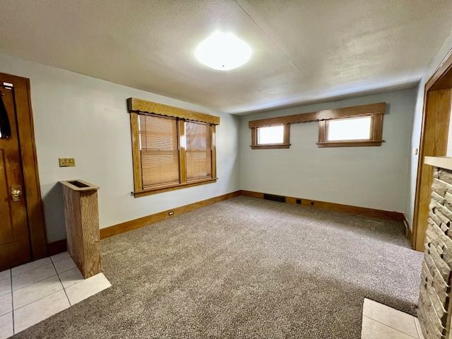 spare room with light carpet and a textured ceiling