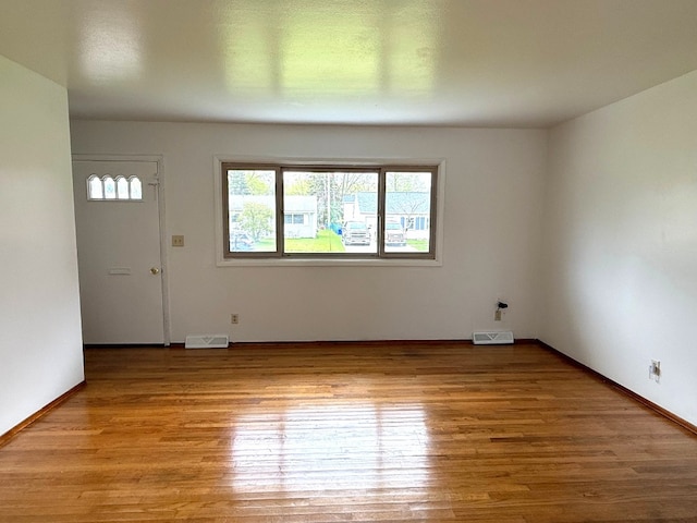 interior space featuring baseboards, visible vents, and wood finished floors