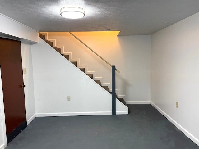 basement with stairway and baseboards