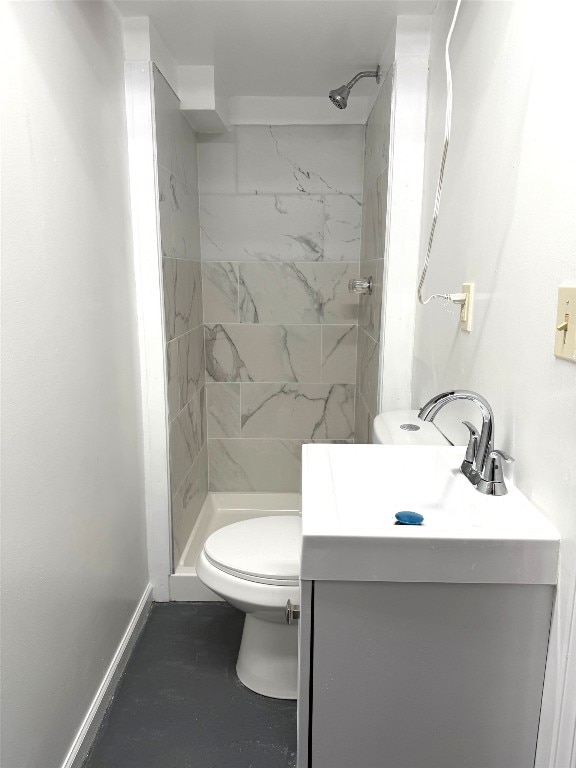bathroom featuring vanity, baseboards, a shower stall, and toilet