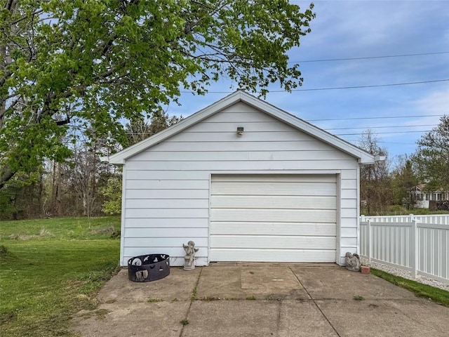 detached garage with fence and concrete driveway