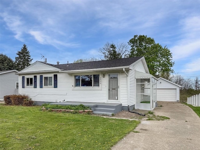 ranch-style home with a garage, an outbuilding, a shingled roof, and a front lawn