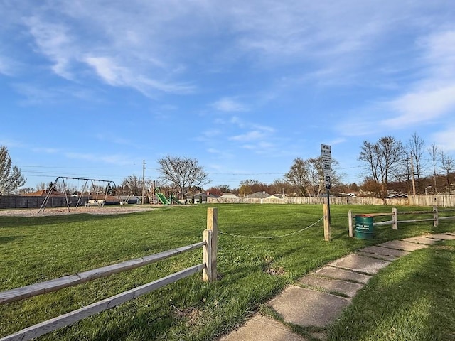 exterior space with a playground, fence, and a yard