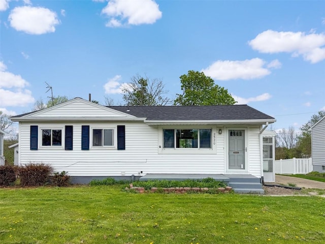 ranch-style home with fence and a front lawn