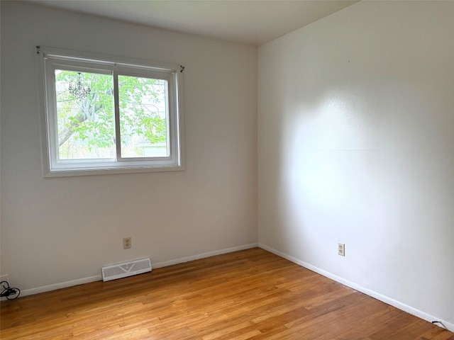 spare room with visible vents, light wood-style floors, and baseboards