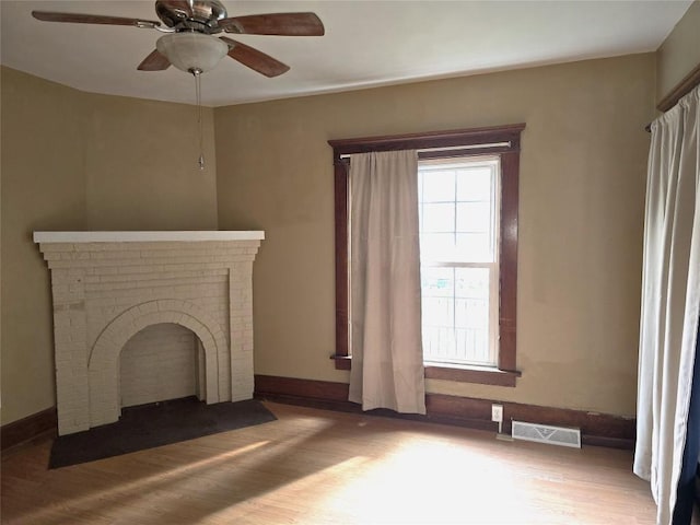 1051-1053 W 9th St, Erie, PA 16502 - unfurnished living room featuring a ceiling fan, wood finished floors, and a fireplace
