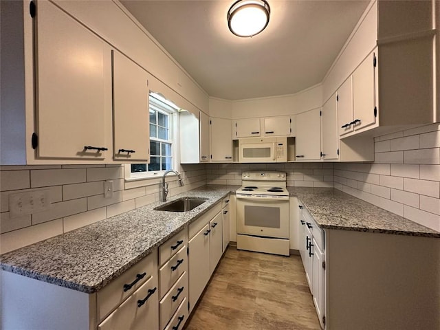 kitchen with light stone countertops, white appliances, tasteful backsplash, and a sink