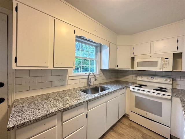 kitchen with white appliances, a sink, white cabinetry, light wood-type flooring, and decorative backsplash