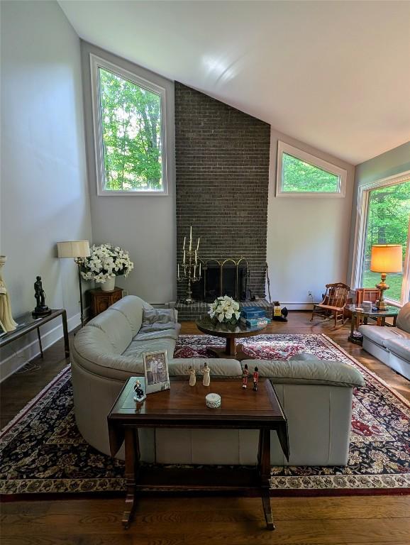 5441 Thomas Rd, Fairview, PA 16415 - living area with vaulted ceiling, a fireplace, healthy amount of natural light, and wood finished floors