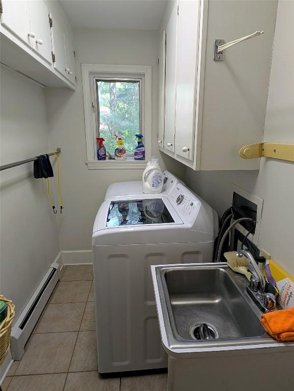 5441 Thomas Rd, Fairview, PA 16415 - laundry area with washing machine and dryer, a baseboard heating unit, cabinet space, light tile patterned floors, and baseboards