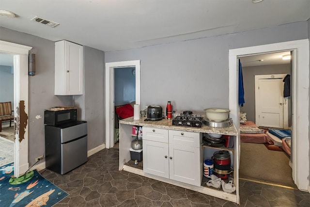 946 W 17th St, Erie, PA 16502 - kitchen with freestanding refrigerator, black microwave, open shelves, and white cabinetry
