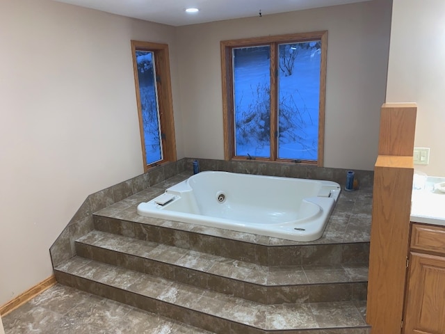 bathroom featuring vanity and tiled tub