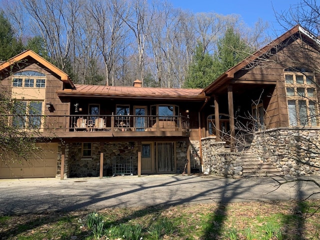 21700 Springs Rd, Meadville, PA 16335 - view of front of house featuring a balcony, a chimney, stone siding, metal roof, and stairs
