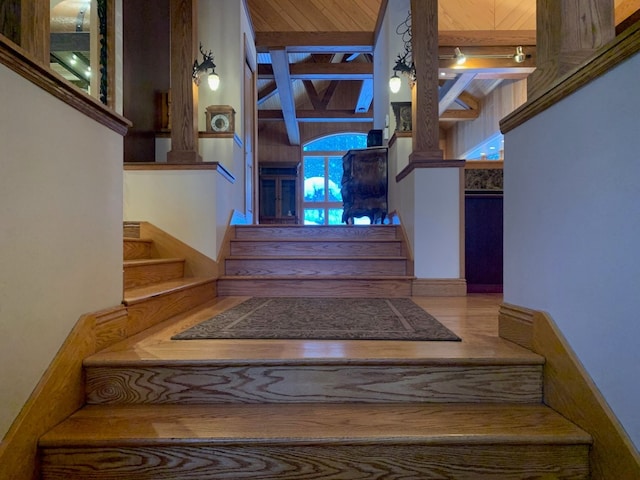 stairway featuring beamed ceiling