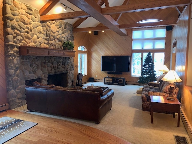 living room with beamed ceiling, carpet flooring, a stone fireplace, and high vaulted ceiling