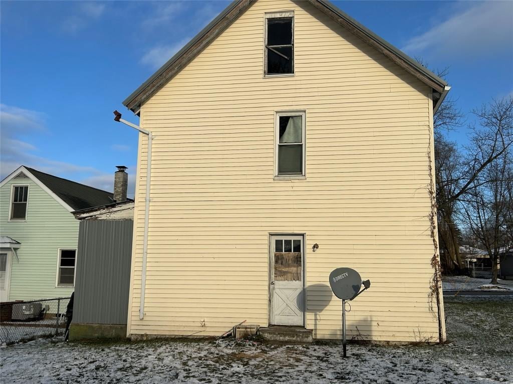 view of snow covered back of property